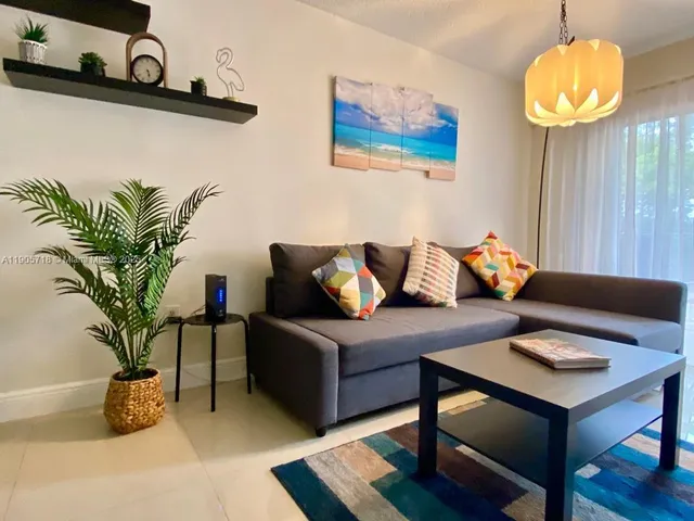 a living room with furniture and a potted plant