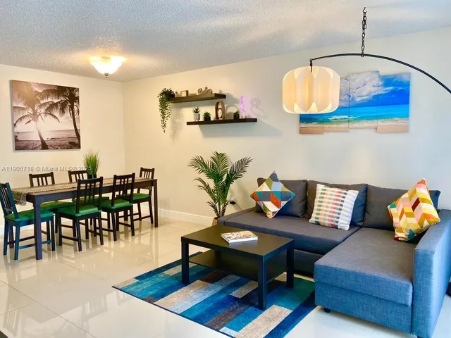 a living room with furniture wooden floor and wall painting