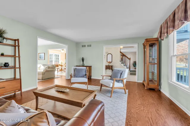 a living room with furniture a wooden floor and next to a window
