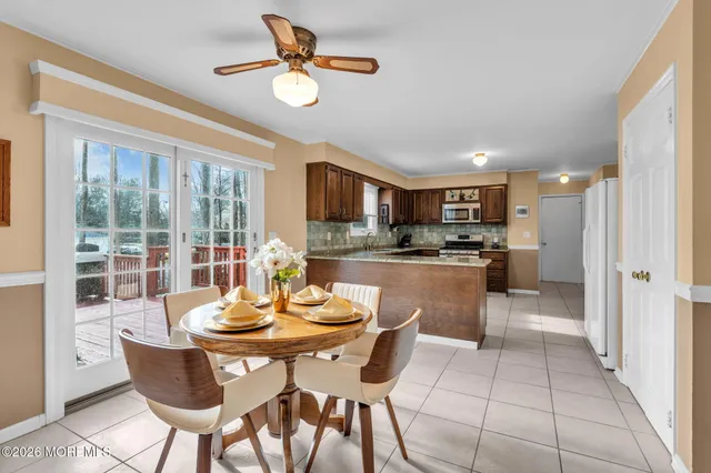 a kitchen with a dining table chairs and refrigerator