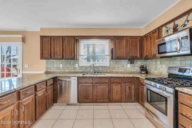 a kitchen with stainless steel appliances granite countertop a stove sink and cabinets