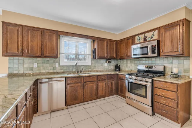 a kitchen with granite countertop a stove sink and cabinets
