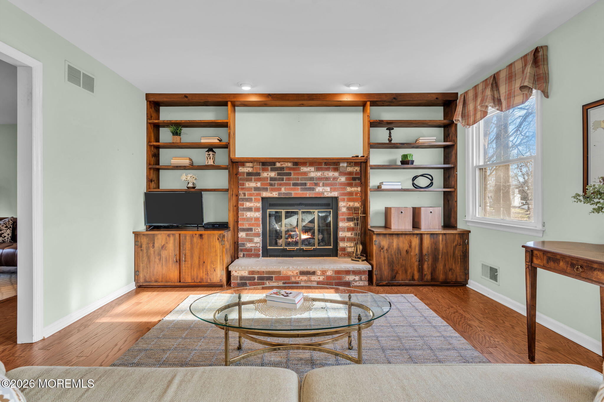 85 Radcliffe Drive Lincroft, NJ 07738 - Photo 32 of 49 a living room with furniture a fireplace and a table