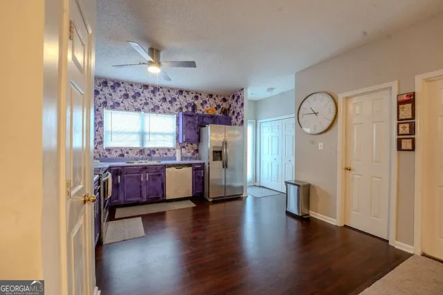 a kitchen with stainless steel appliances granite countertop a refrigerator a stove and a wooden floors