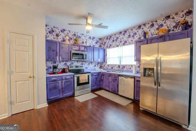 a kitchen with stainless steel appliances granite countertop a refrigerator a sink dishwasher a oven with wooden floor and cabinets