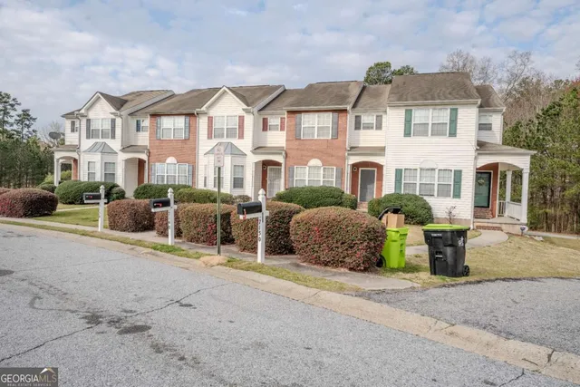 a front view of a house with a garden and plants