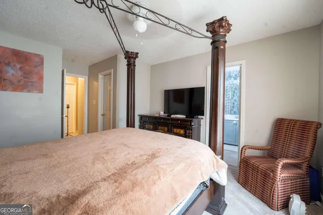 a bedroom with a bed flat screen tv and a couch