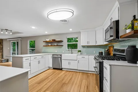 a kitchen with stainless steel appliances granite countertop a stove sink and cabinets