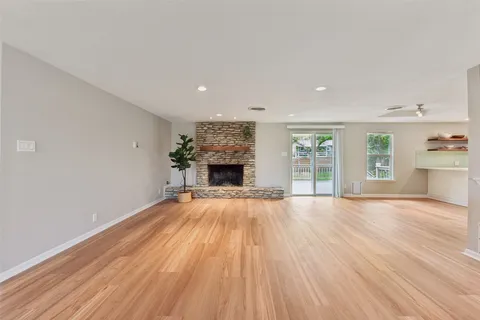 an empty room with wooden floor and fireplace