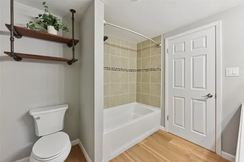 a white toilet sitting next to a bathtub