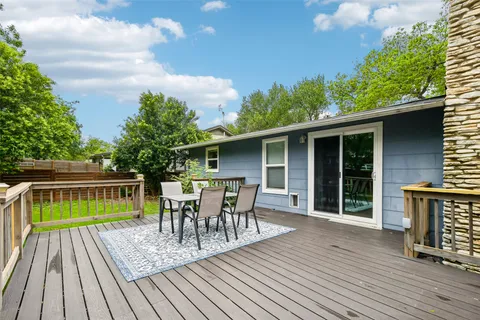 a view of house with a deck and furniture