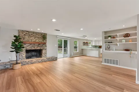 a view of an empty room with a fireplace and a window