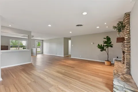 a view of a big room with wooden floor and potted plants