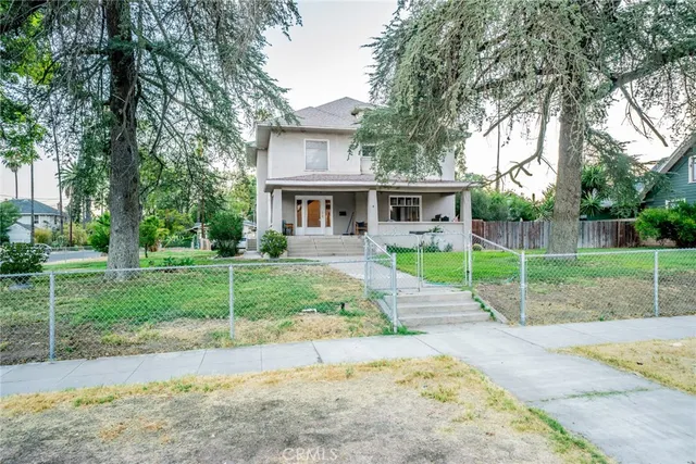 a view of a house with a backyard and a tree