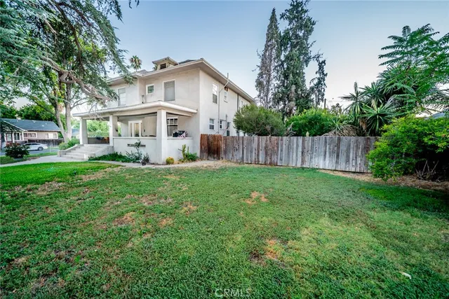 a view of a house with backyard and a tree
