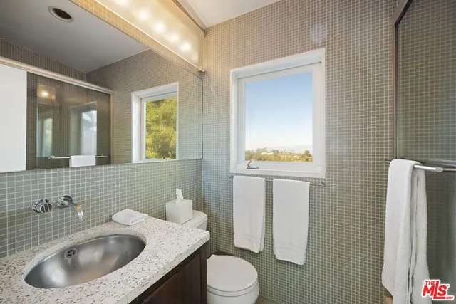 a bathroom with a sink a toilet and mirror