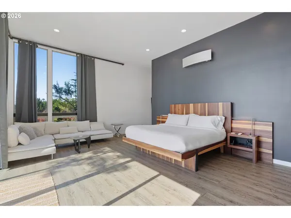 a bedroom with furniture and a large window