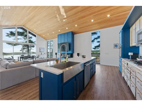 a kitchen with stainless steel appliances granite countertop a sink a stove and a wooden floors