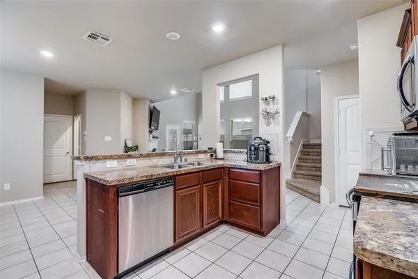a kitchen with stainless steel appliances granite countertop a stove a sink and a microwave