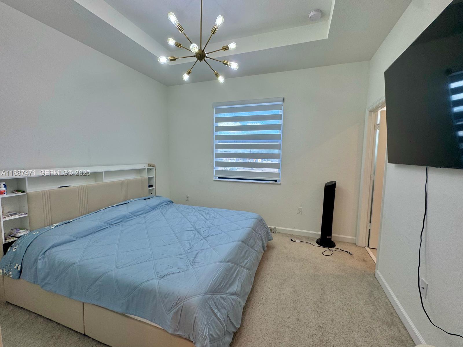 23541 Southwest 127th Place Homestead, FL 33032 - Photo 5 of 13 a bedroom with a bed and a flat screen tv