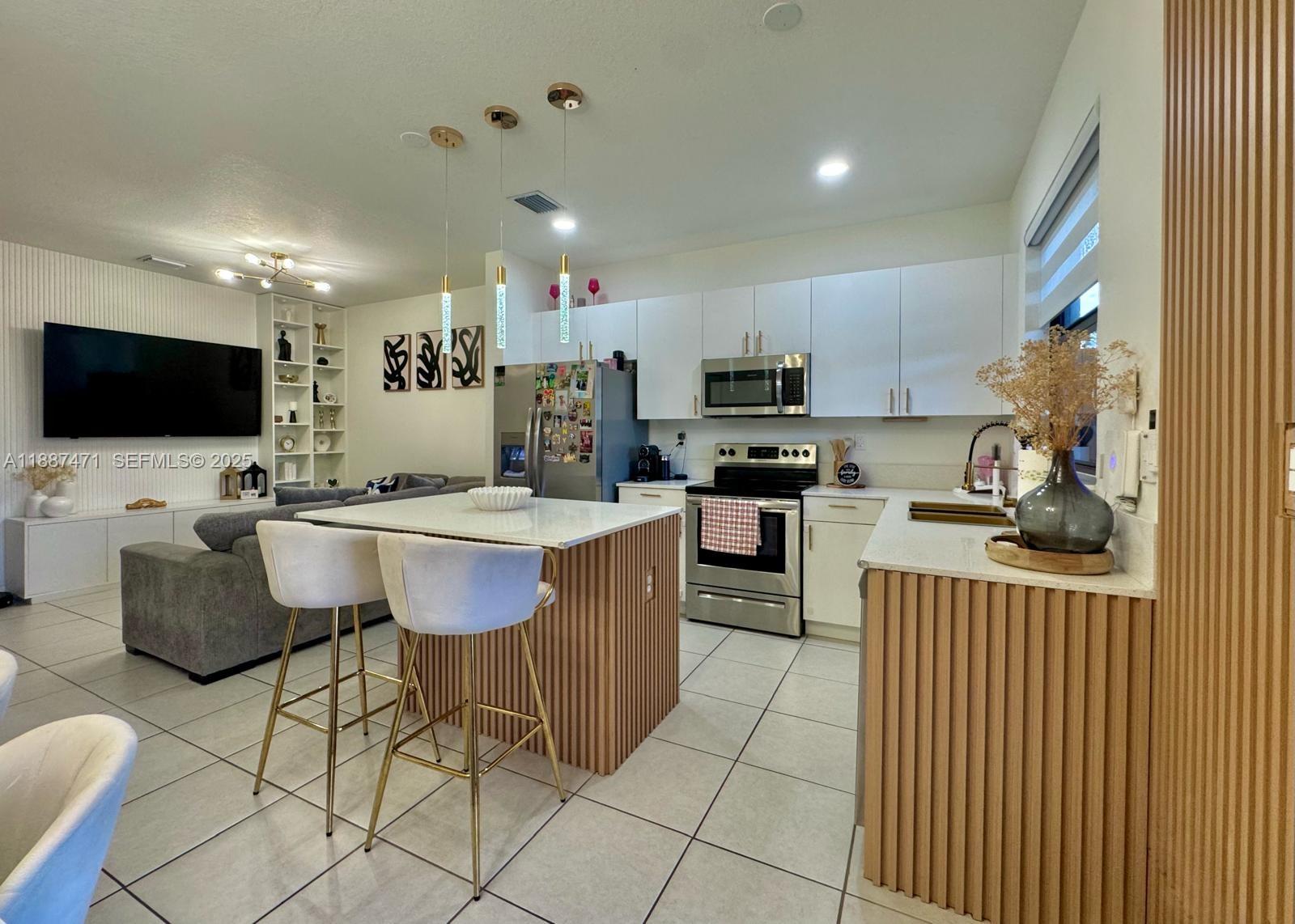 23541 Southwest 127th Place Homestead, FL 33032 - Photo 10 of 13 a room with furniture a flat screen tv and kitchen view