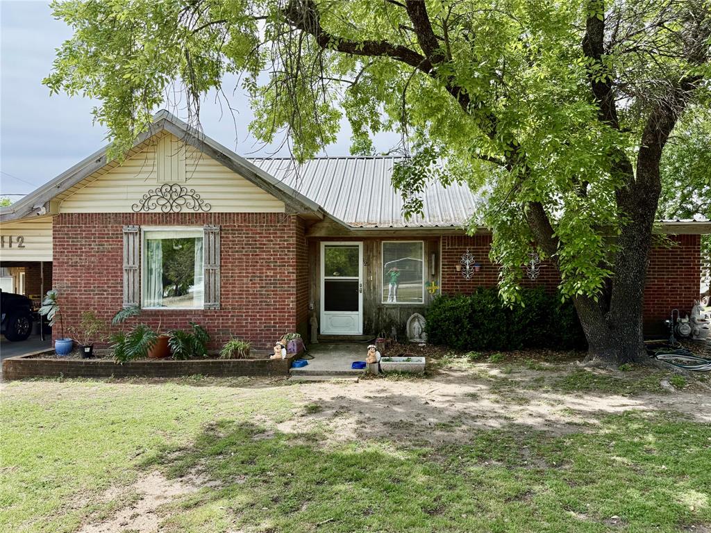 a front view of a house with a yard and potted plants