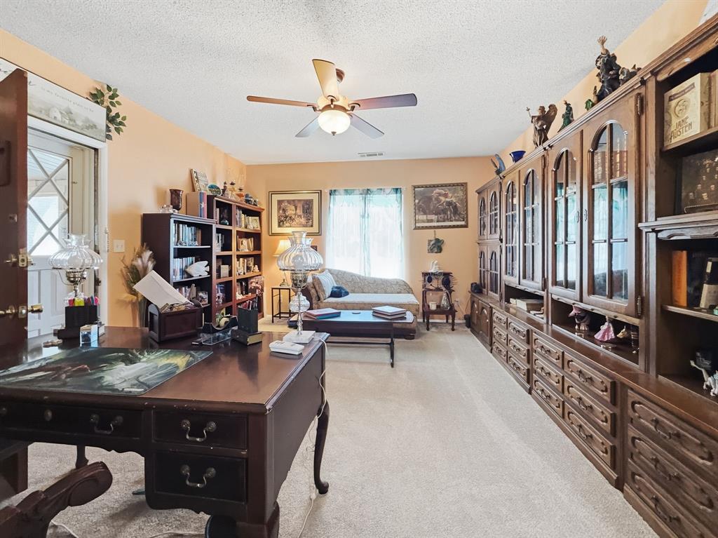 112 East Hoard Street Hamilton, TX 76531 - Photo 5 of 26 a living room with a couch bookshelf and a window