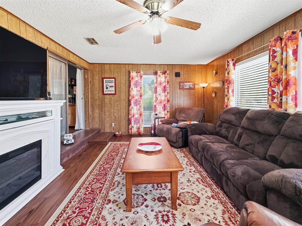 112 East Hoard Street Hamilton, TX 76531 - Photo 8 of 26 a living room with furniture a flat screen tv and a fireplace