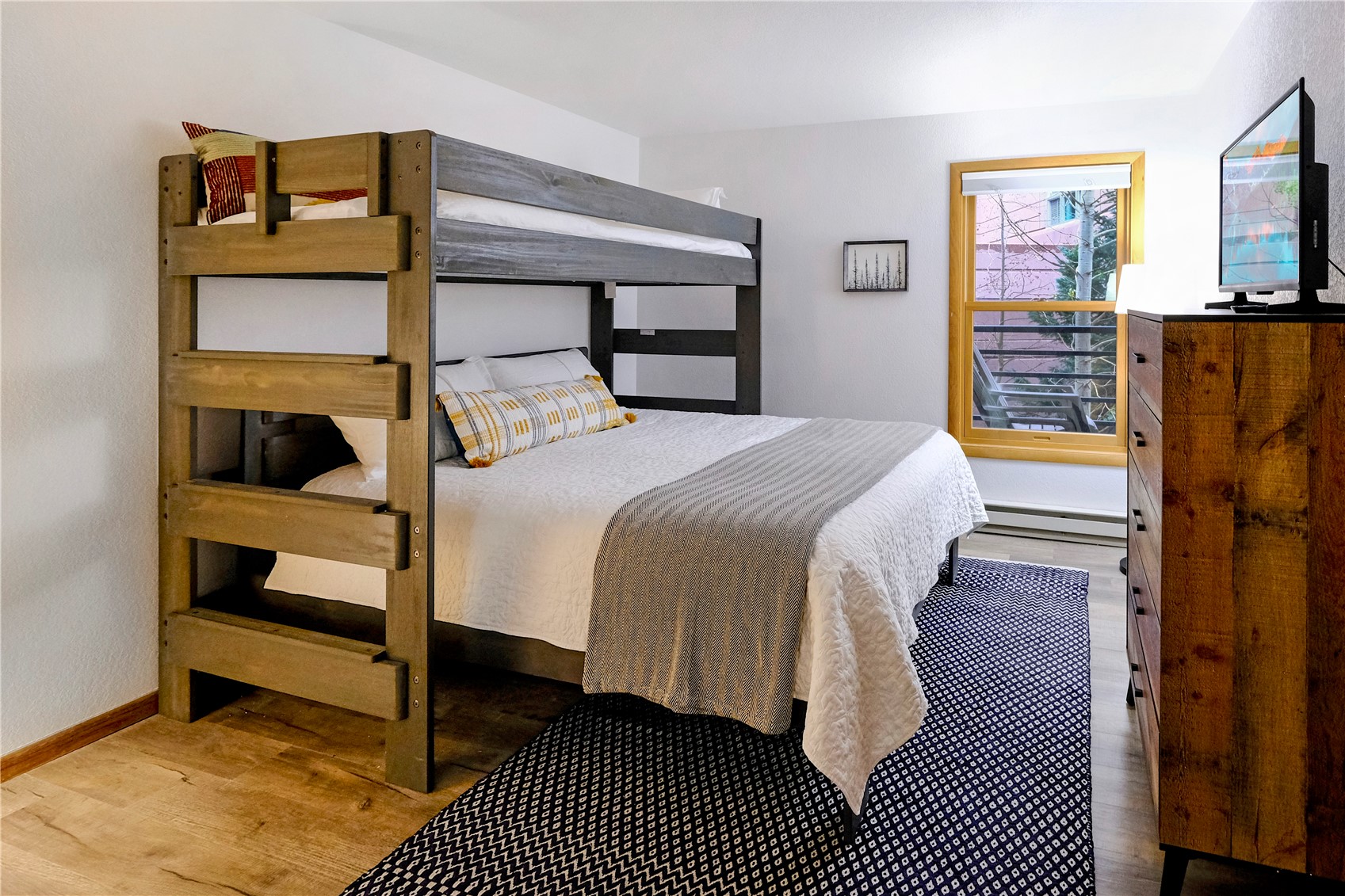 23034 Highway 6, Unit 305 Keystone, CO 80435 - Photo 13 of 27 a bedroom with a bed and wooden floor