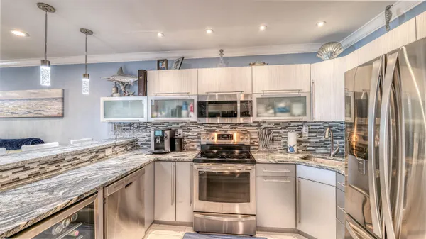 a kitchen with stainless steel appliances granite countertop a stove a sink and a refrigerator
