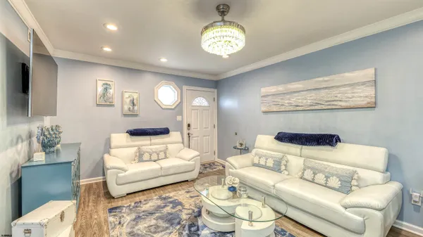 a living room with furniture and a chandelier