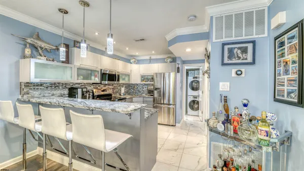 a kitchen with stainless steel appliances granite countertop a sink refrigerator and cabinets