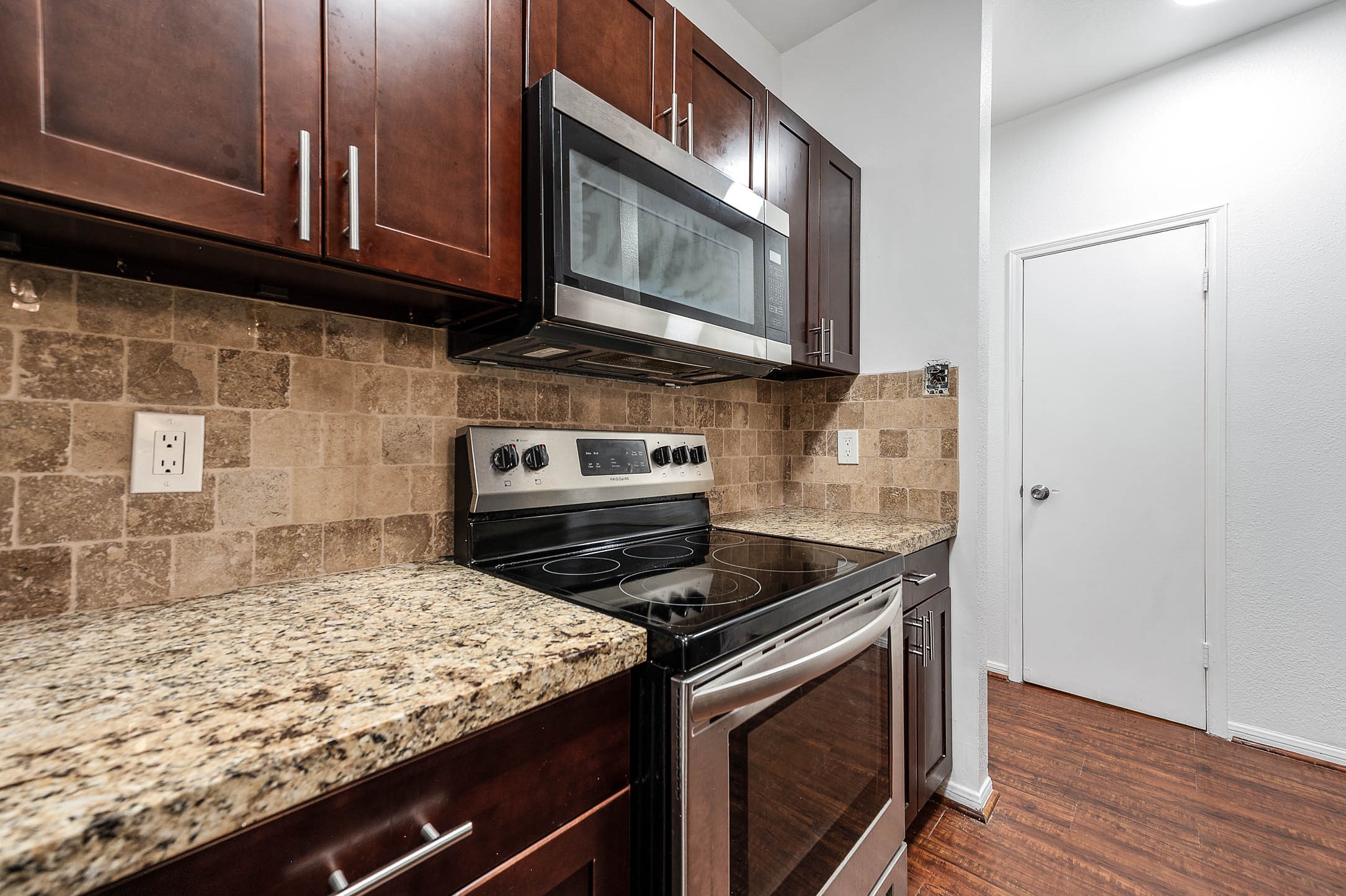6000 Reims Road, Unit 2003 Houston, TX 77036 - Photo 10 of 24 a kitchen with granite countertop stainless steel appliances and wooden cabinets