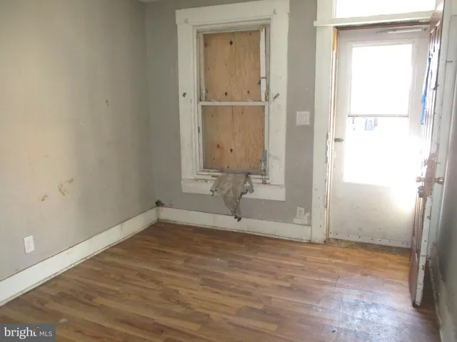 a view of empty room with wooden floor