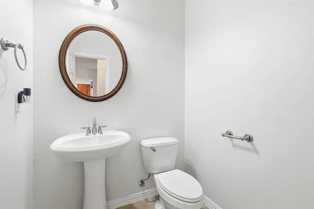 a bathroom with a toilet a sink and a mirror