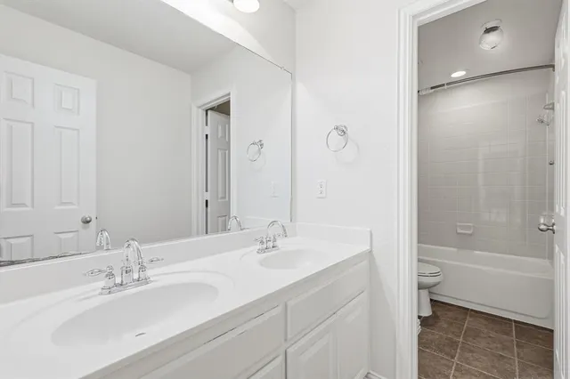 a bathroom with a bathtub shower sink and a toilet