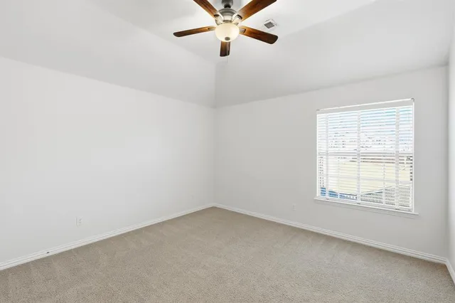 an empty room with a window and a fan