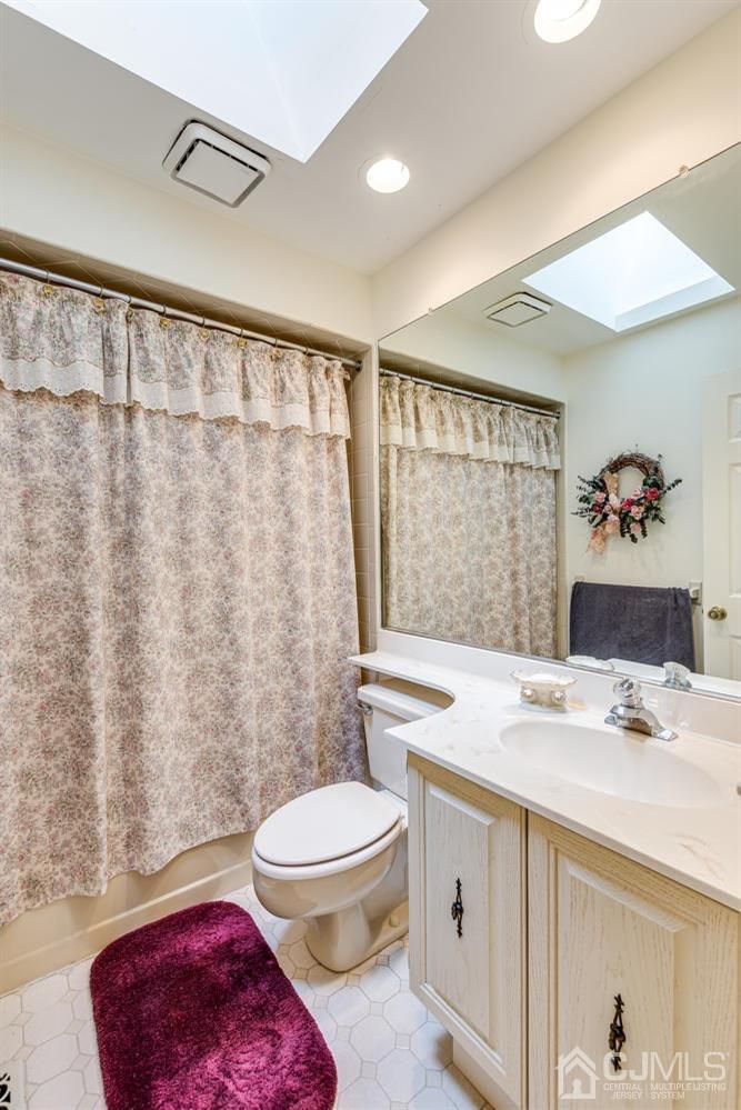 4303 Springbrook Drive Edison, NJ 08820 - Photo 32 of 40 a bathroom with a sink a toilet and shower curtain