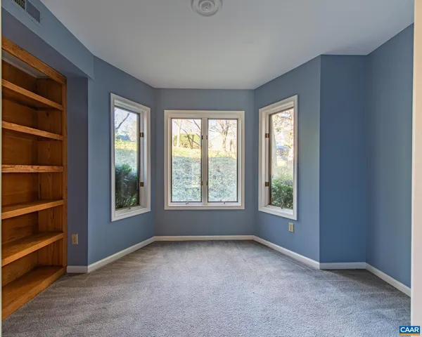 an empty room with windows and closet