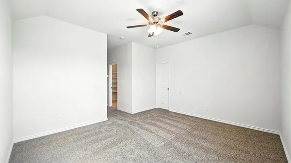 an empty room with a ceiling fan and a window