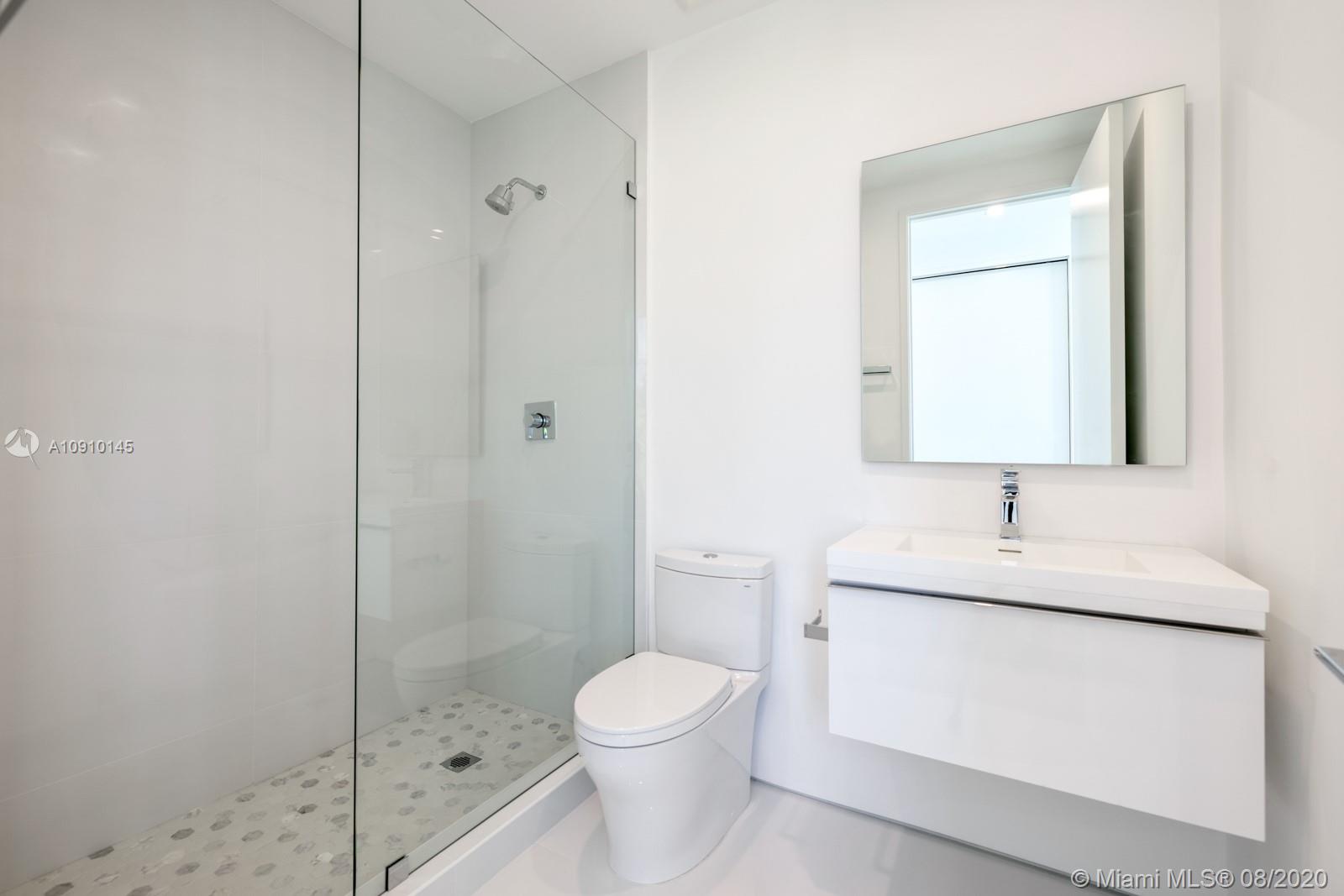6493 Allison Road Miami Beach, FL 33141 - Photo 22 of 41 a bathroom with a granite countertop sink a toilet and shower