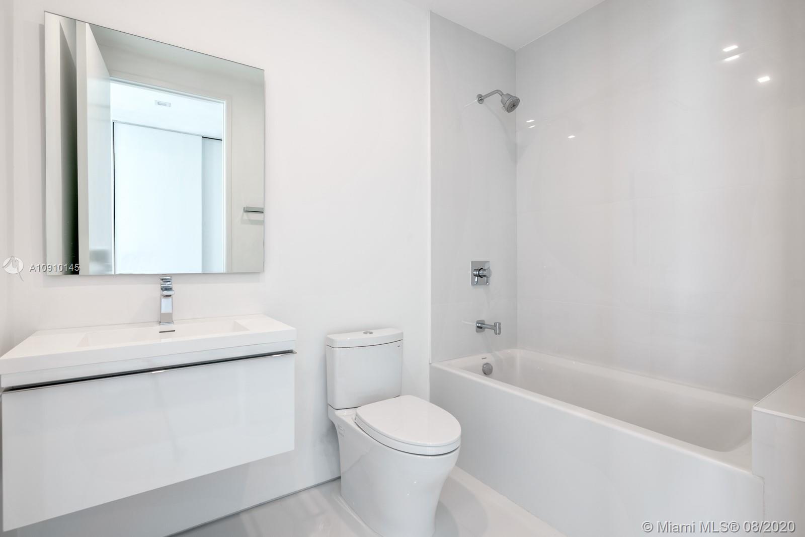 6493 Allison Road Miami Beach, FL 33141 - Photo 24 of 41 a bathroom with a toilet sink and mirror