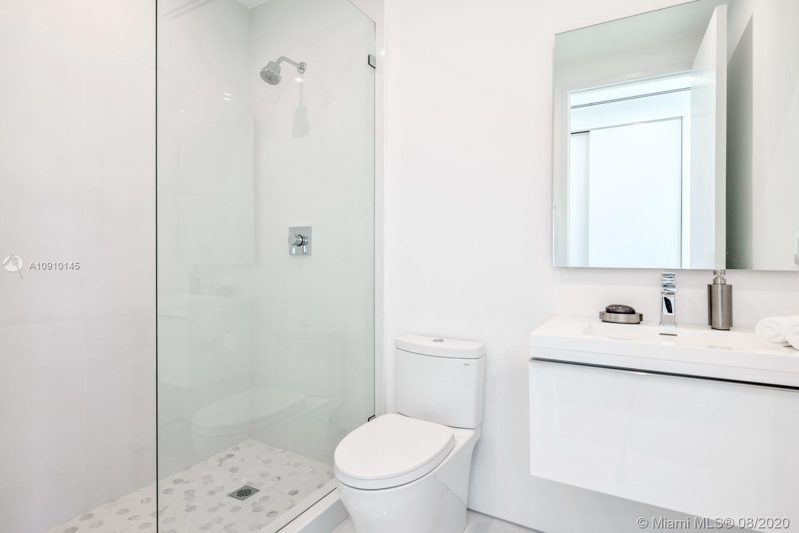 6493 Allison Road Miami Beach, FL 33141 - Photo 28 of 41 a bathroom with a toilet sink vanity and shower