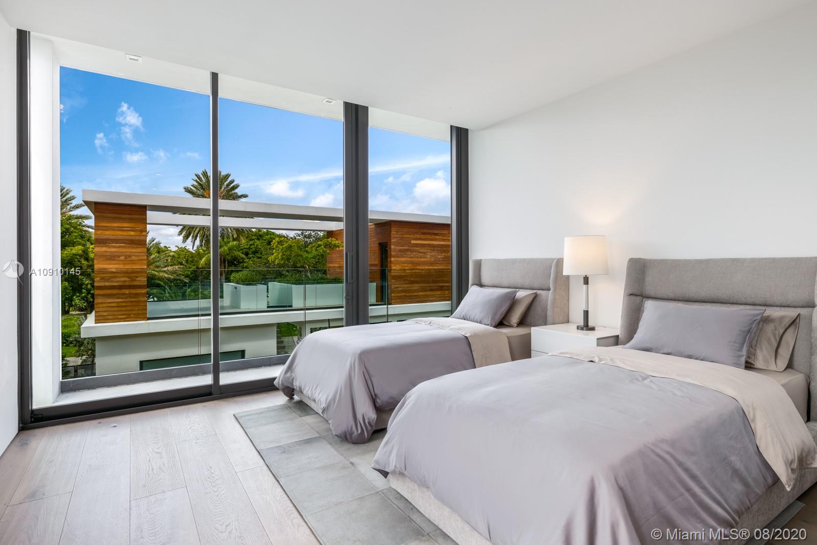 6493 Allison Road Miami Beach, FL 33141 - Photo 29 of 41 a bedroom with two large window and a bed