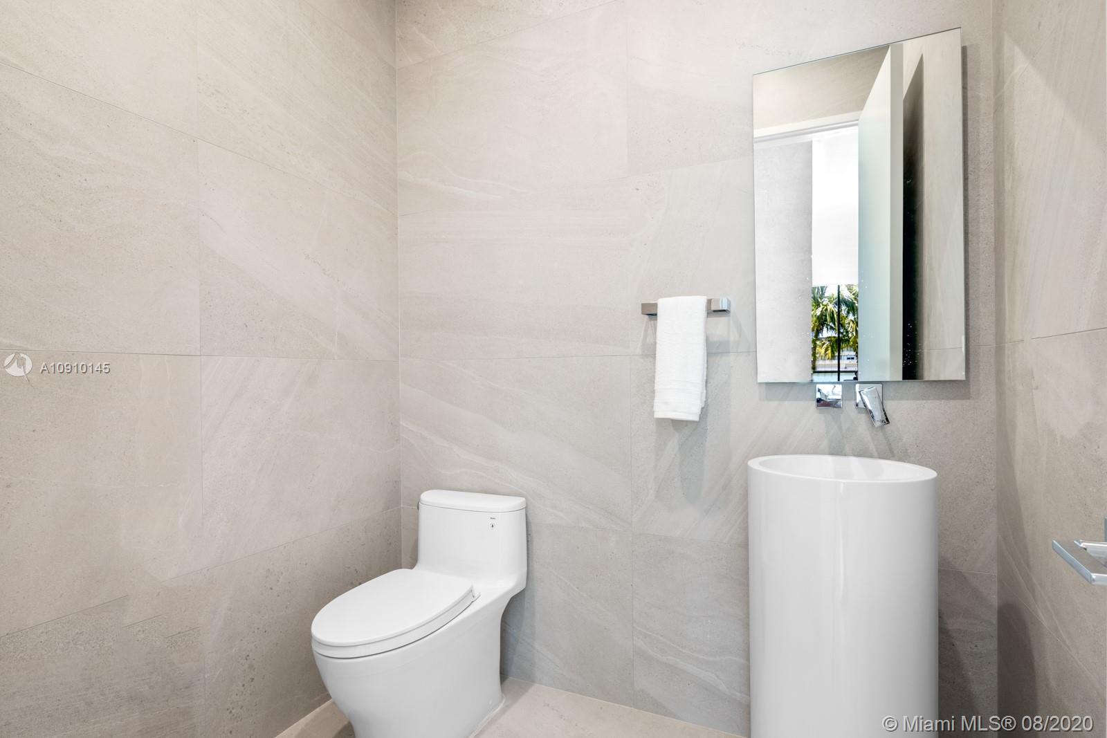 6493 Allison Road Miami Beach, FL 33141 - Photo 35 of 41 a bathroom with a toilet sink and mirror