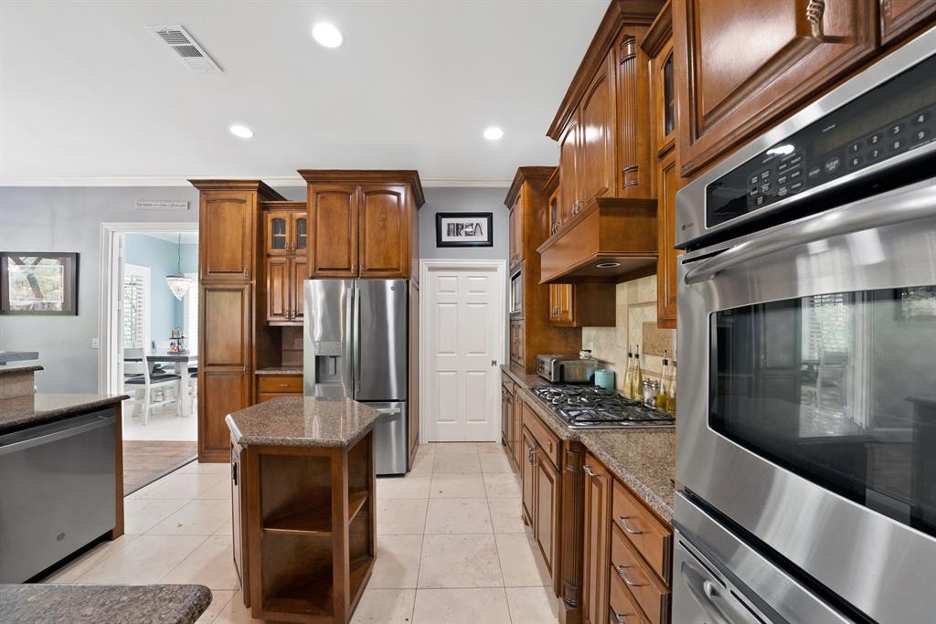 621 Diamond Point Drive Oak Point, TX 75068 - Photo 13 of 40 a kitchen with stainless steel appliances kitchen island granite countertop a refrigerator and stove
