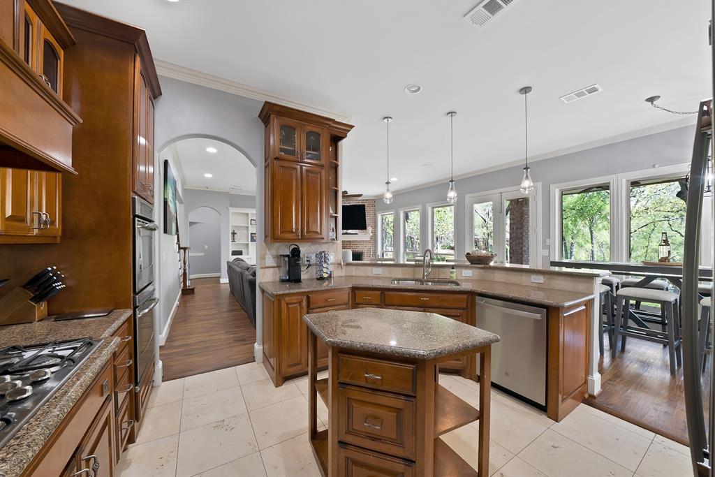 621 Diamond Point Drive Oak Point, TX 75068 - Photo 8 of 40 a kitchen with granite countertop a stove a sink a dining table and chairs