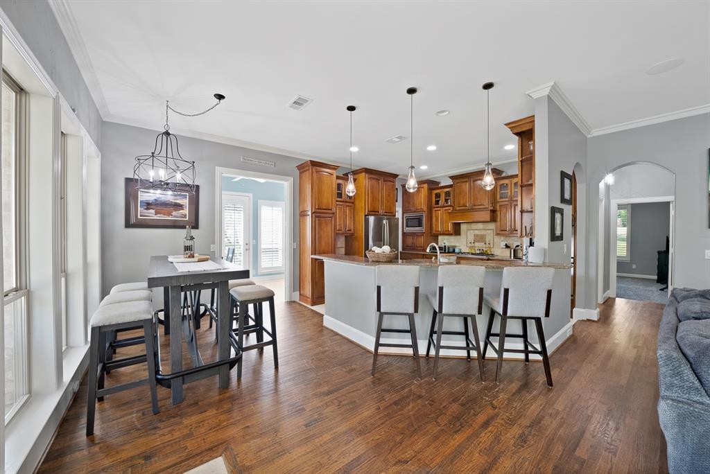 621 Diamond Point Drive Oak Point, TX 75068 - Photo 9 of 40 a open kitchen with stainless steel appliances granite countertop a dining table and chairs with wooden floor