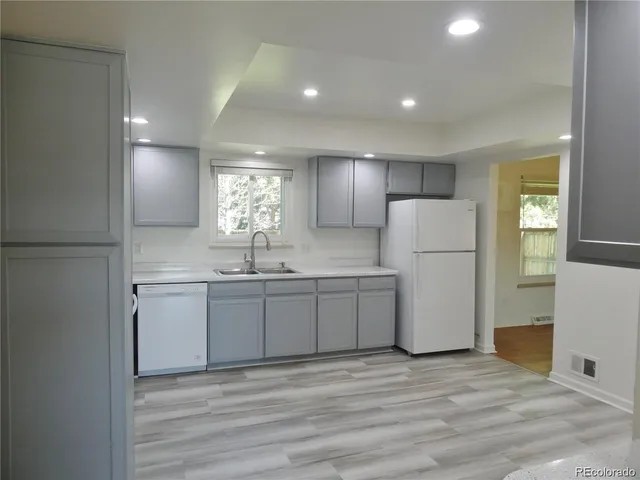 a kitchen with a refrigerator sink and cabinets