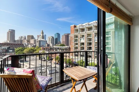a view of a balcony with wooden floor and outdoor seating